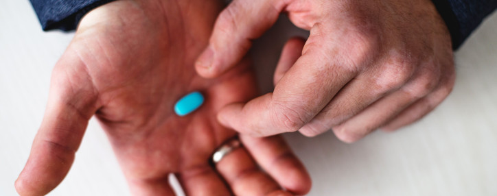 Hand holding blue pill