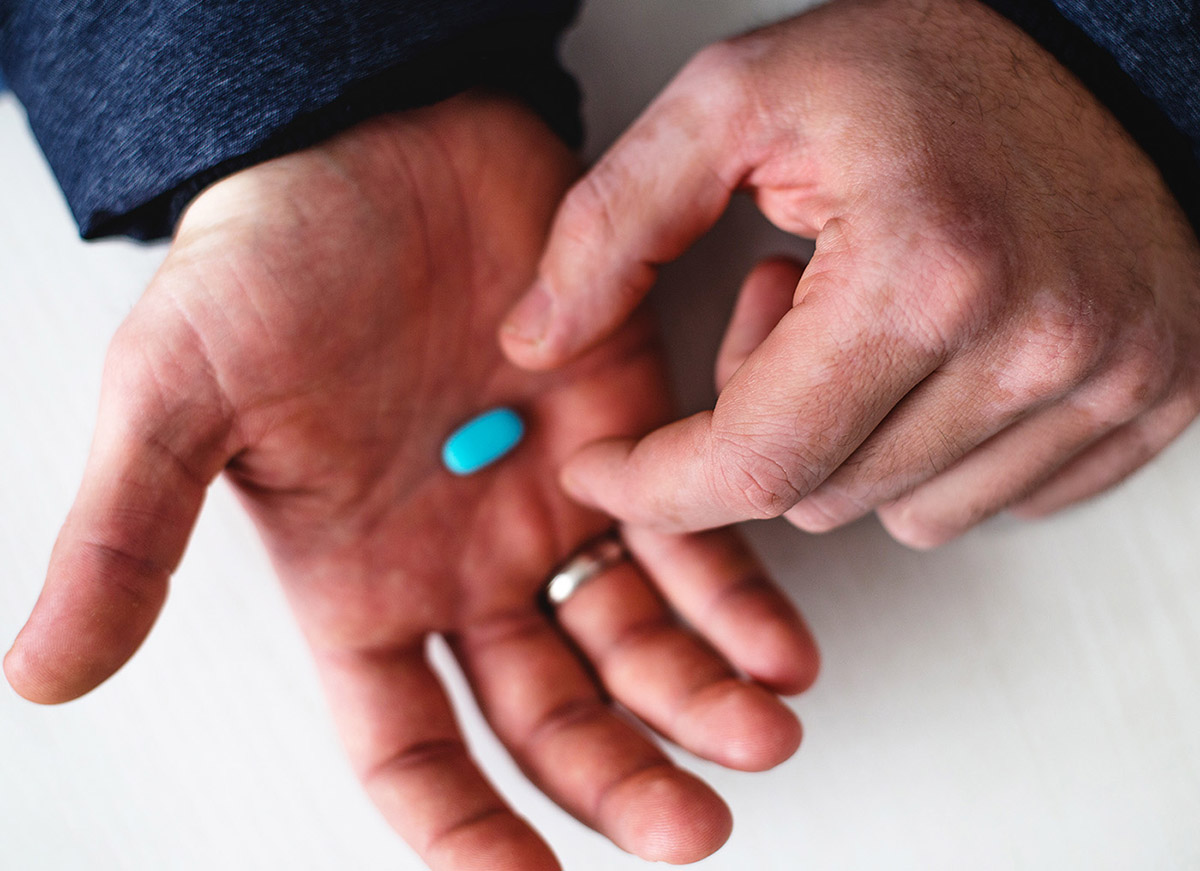 Hand holding blue pill